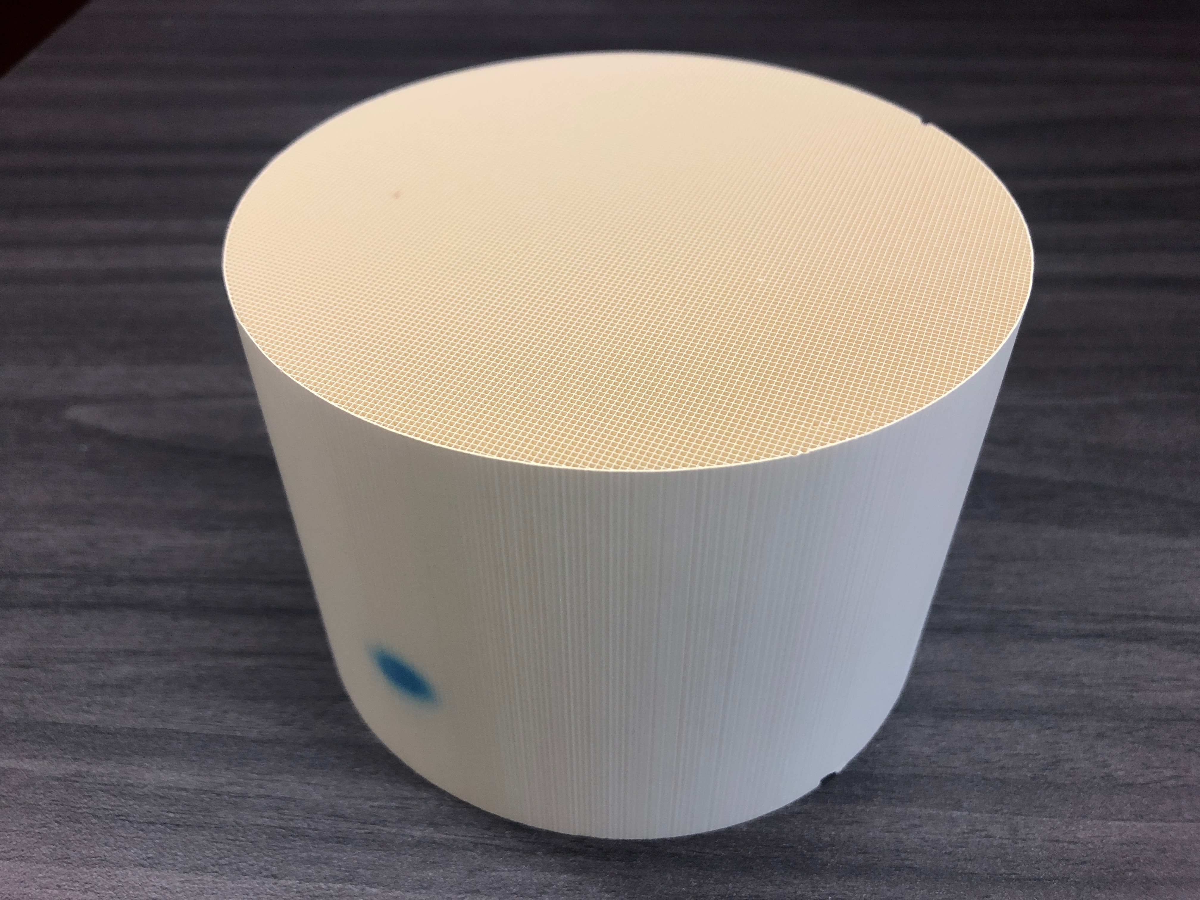 A ceramic cylinder with a fine mesh inside.
